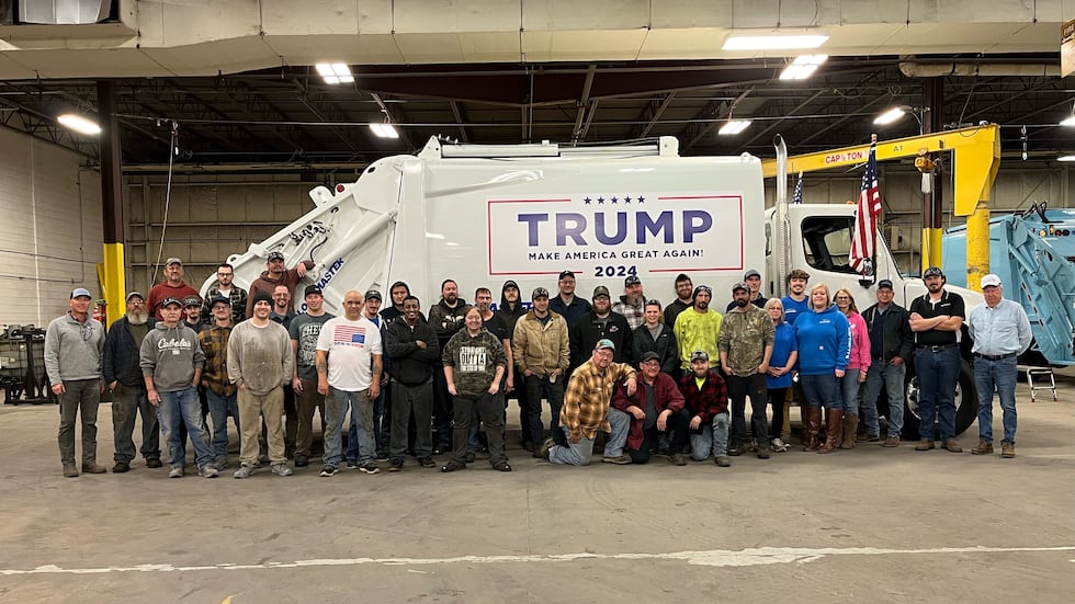 Loadmaster employees pose with the garbage truck that Donald Trump posed for photo ops with....