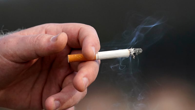 FILE - A man holds a lit cigarette while smoking in San Francisco, Wednesday, Dec. 2, 2020.
